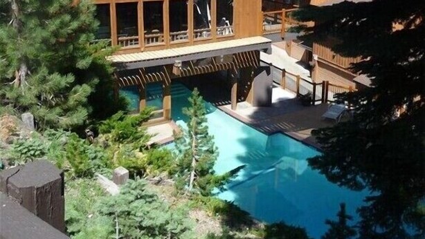 A large wooden building with a pool, surrounded by trees and mountains. - LUXURY VIEW CONDO/SKI-IN/SKI-OUT/TO CANYON/EAGLE EXPRESS (Mammoth Lakes)