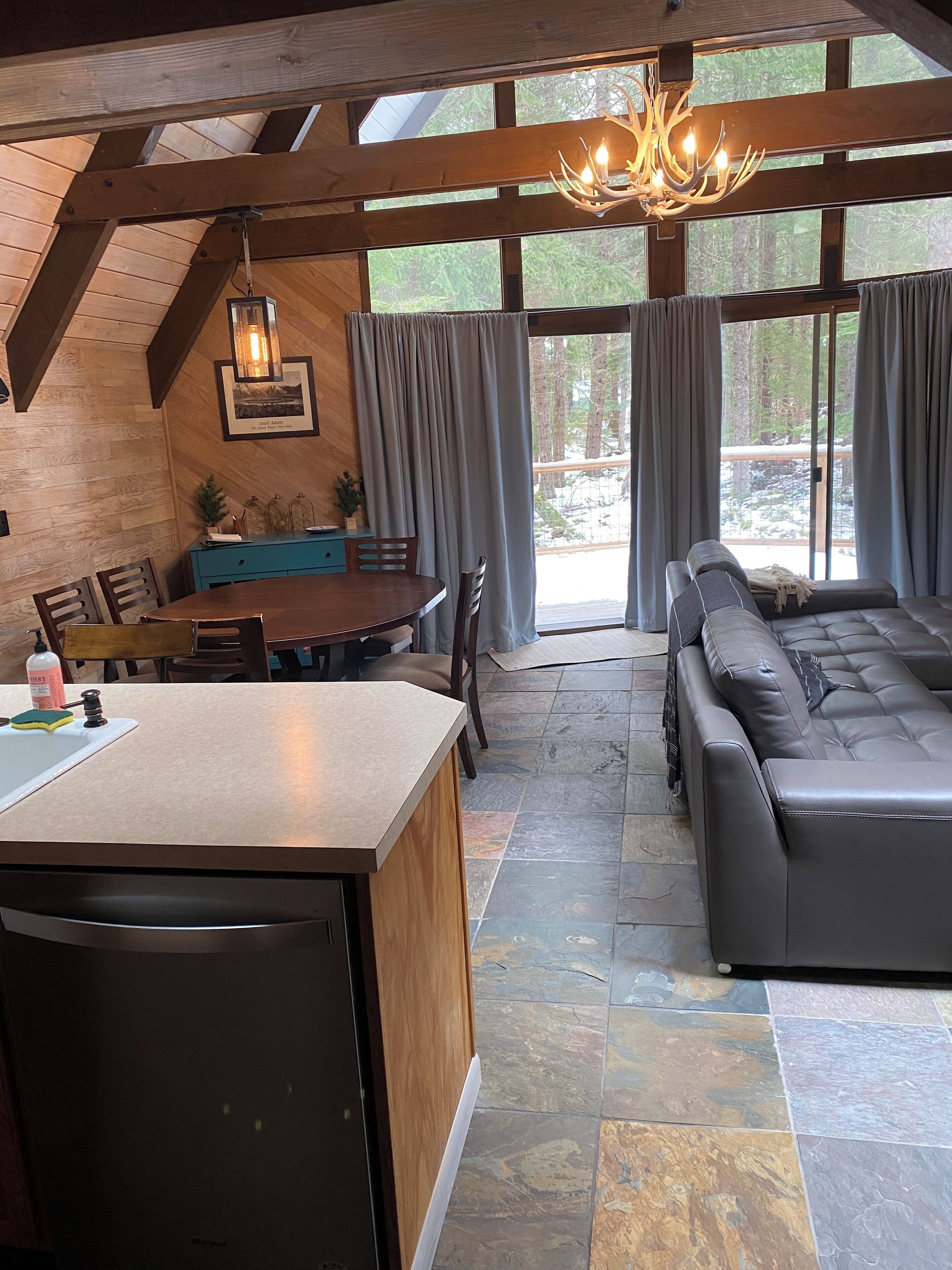 Amplia sala de estar con una mesa de comedor, un sofá y una zona de cocina con mostrador.