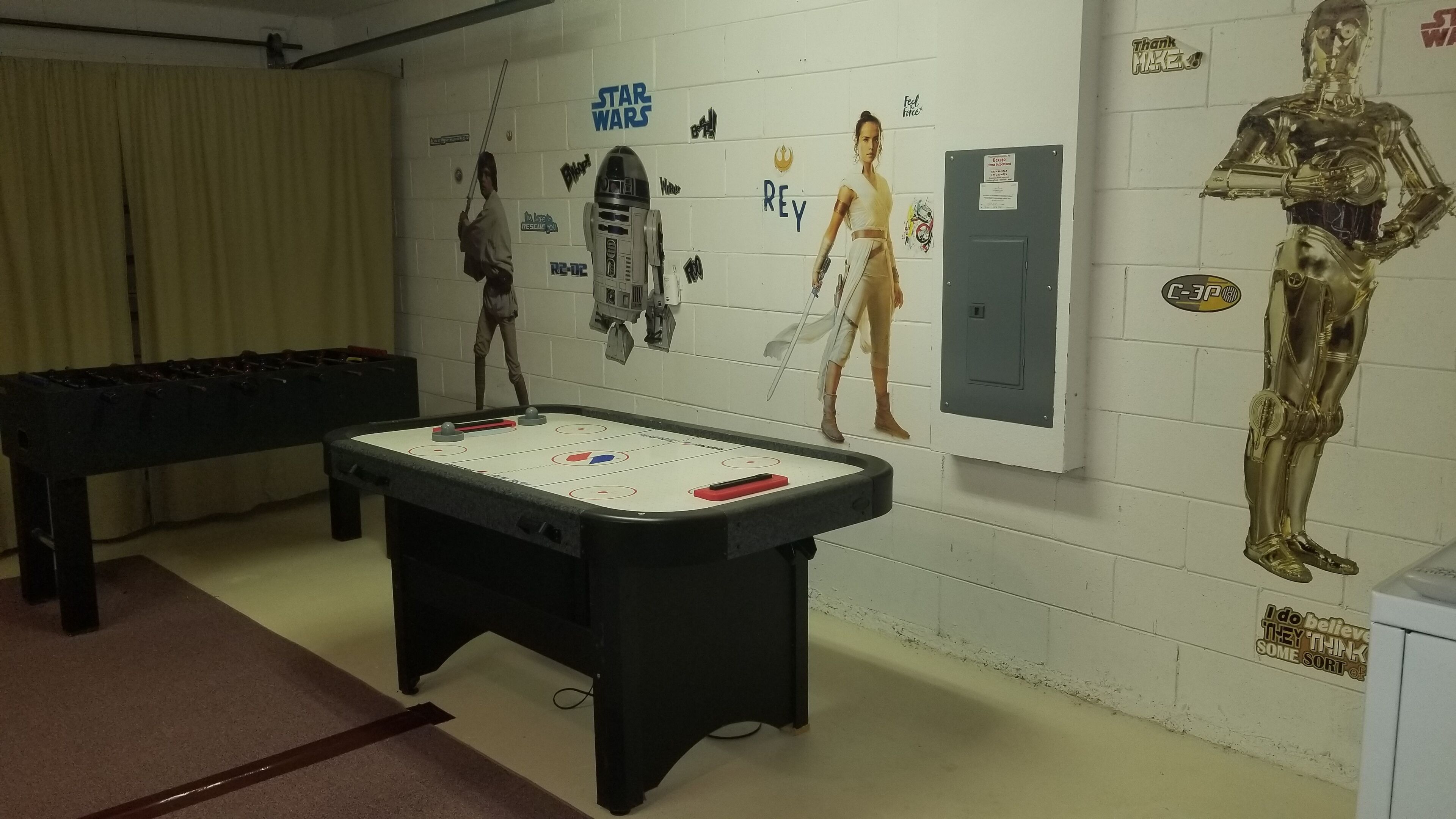 A room with a foosball table, Star Wars decorations, and a Star Wars-themed poster.