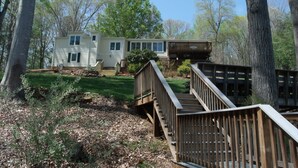 A two-story house with a deck and stairs leading to a balcony.