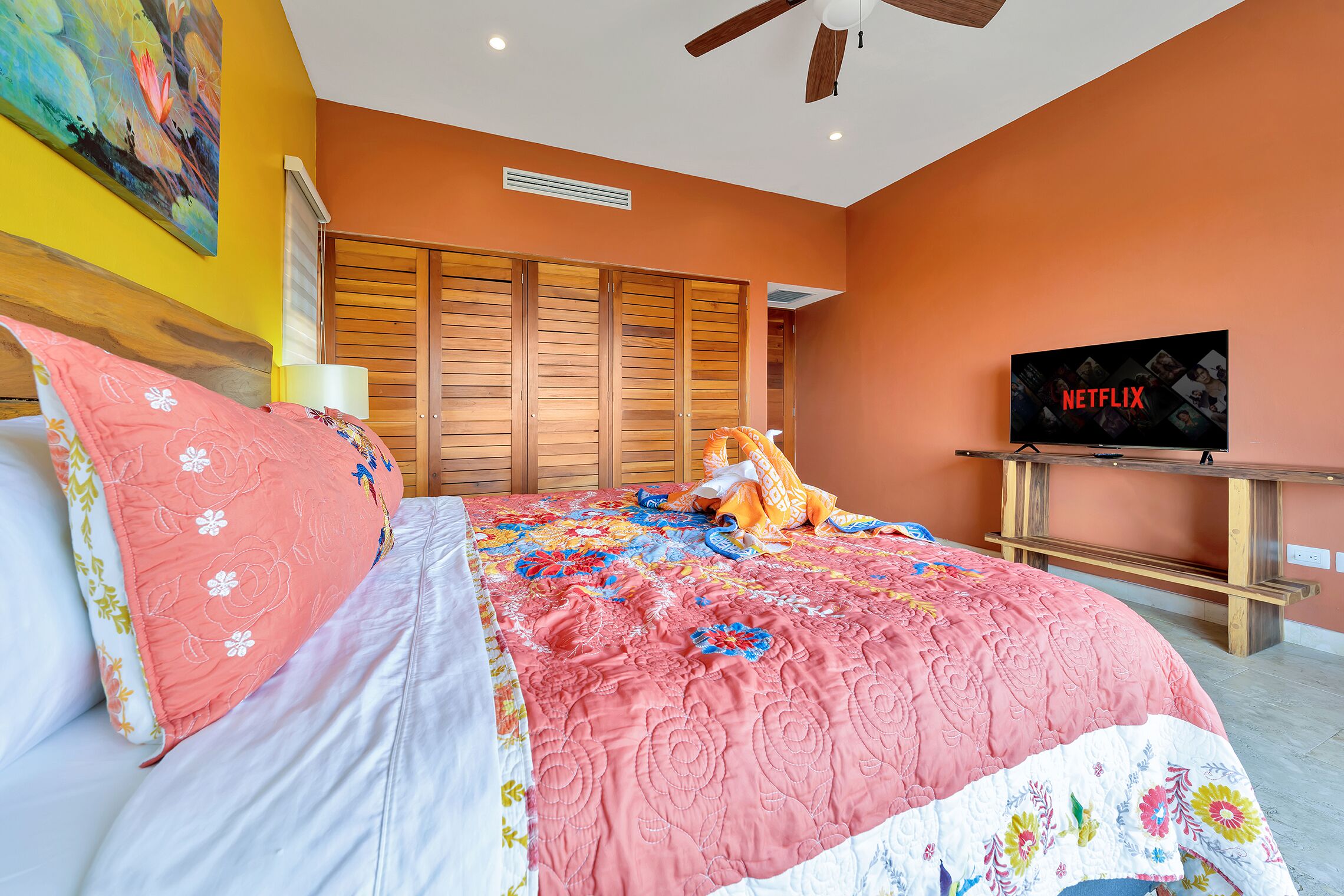 A bedroom with a bed, a television, and a wardrobe.