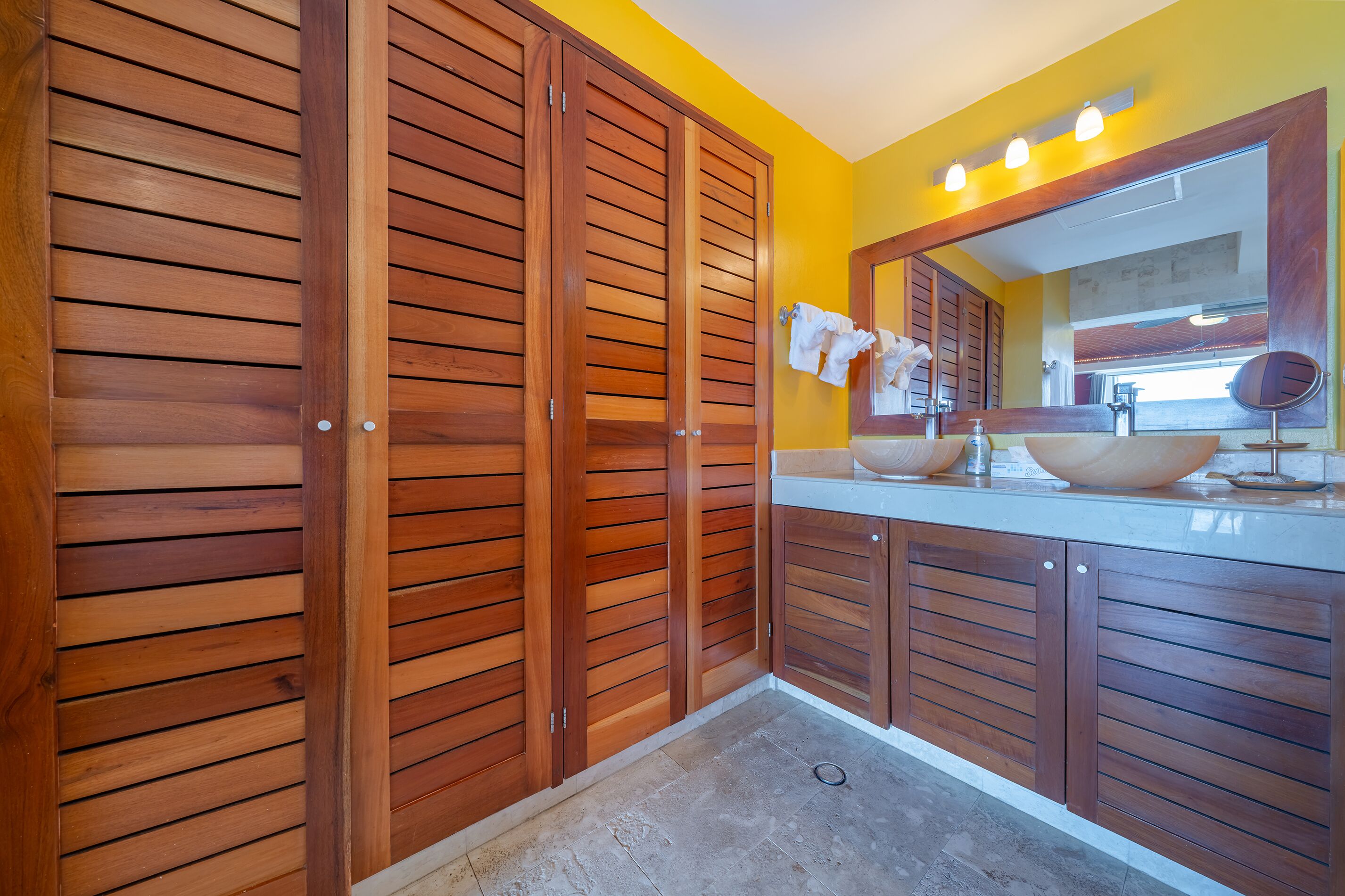 A bathroom with wooden cabinets, a sink, and a mirror.