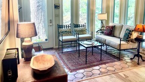 Un salon chaleureux avec un canapé, deux fauteuils, une table basse et un tapis.