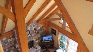A wooden beam structure, a stone fireplace, and a television in a room. - Perfect For Family Reunions/Weekend Getaways/Large Groups. A hidden oasis! (Fish Creek)