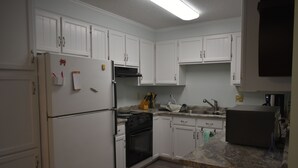 A kitchen with white cabinets, a refrigerator, stove, oven, and a microwave. - Carolina Beach Spectacular Views from Front & Back,  Pool & Wifi - Renovated (Carolina Beach)
