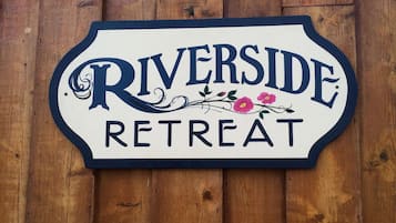 Une enseigne pour Riverside Retreat sur un fond en bois.