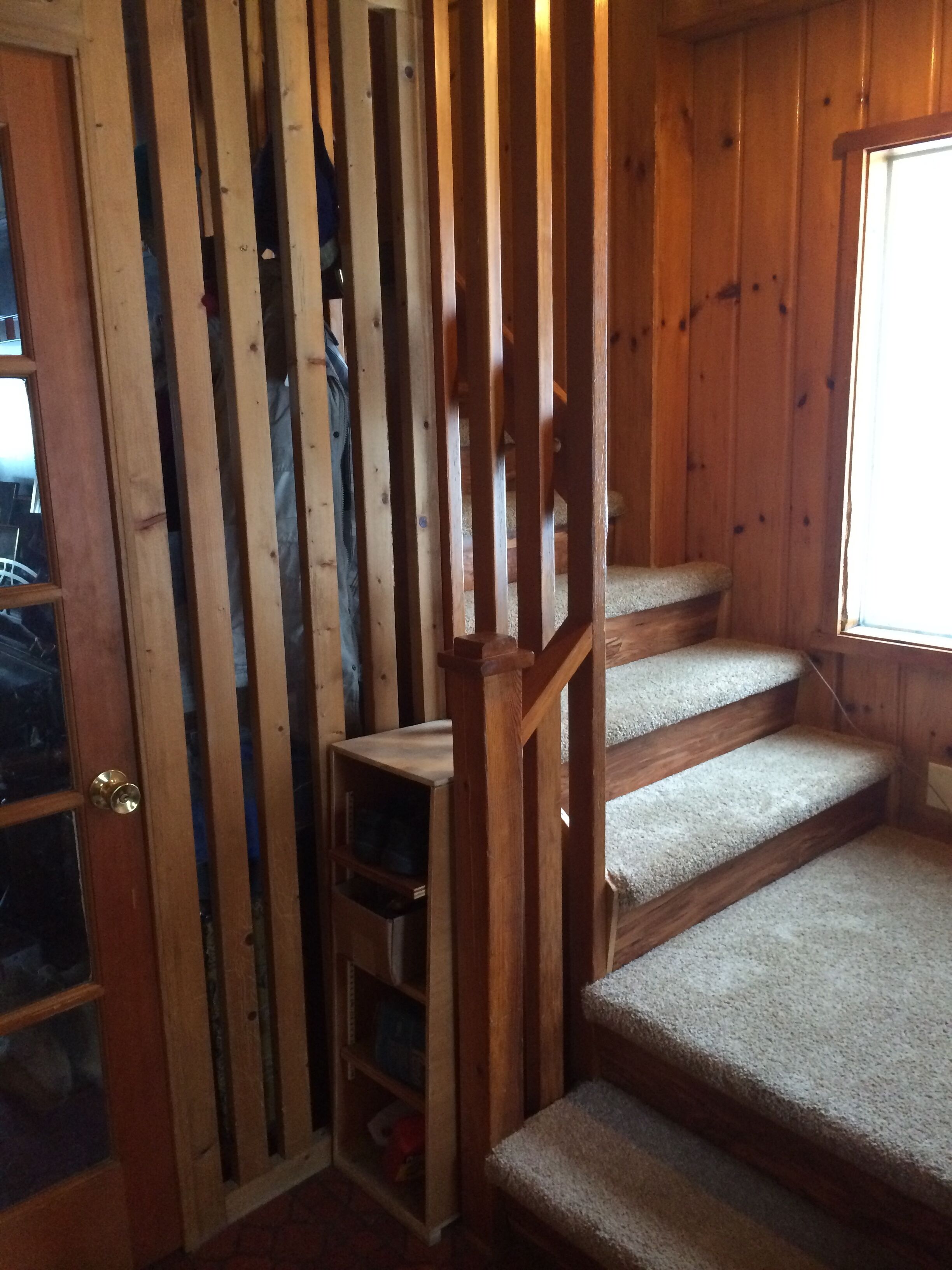 A wooden staircase with carpeted steps leading to an upper level.