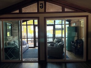 A room with a large sliding glass door leading to an outdoor deck, a sofa, and a green cabinet.