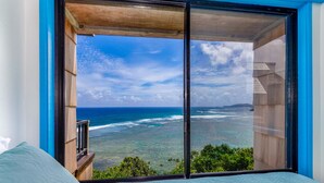 Una habitación con un amplio ventanal con vista a la playa y al océano.