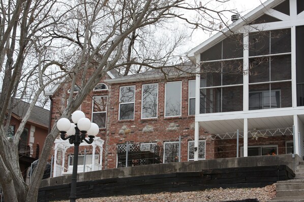 A brick building with large windows and a covered porch.