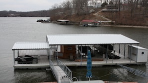 A houseboat with a covered deck, outdoor seating, and a grill area. - 2 Master Suites, Incredible Views Sleeps 10-12, Great Dock (Sunrise Beach)