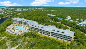 Un complexe hôtelier comprenant plusieurs bâtiments, une piscine et une zone boisée environnante.