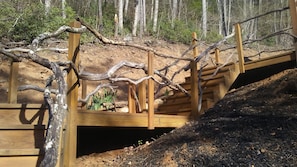 Cross a wooden bridge over a scenic rocky terrain, offering access to a natural landscape.