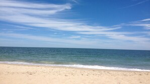 Una playa con cielo despejado y mar tranquilo.