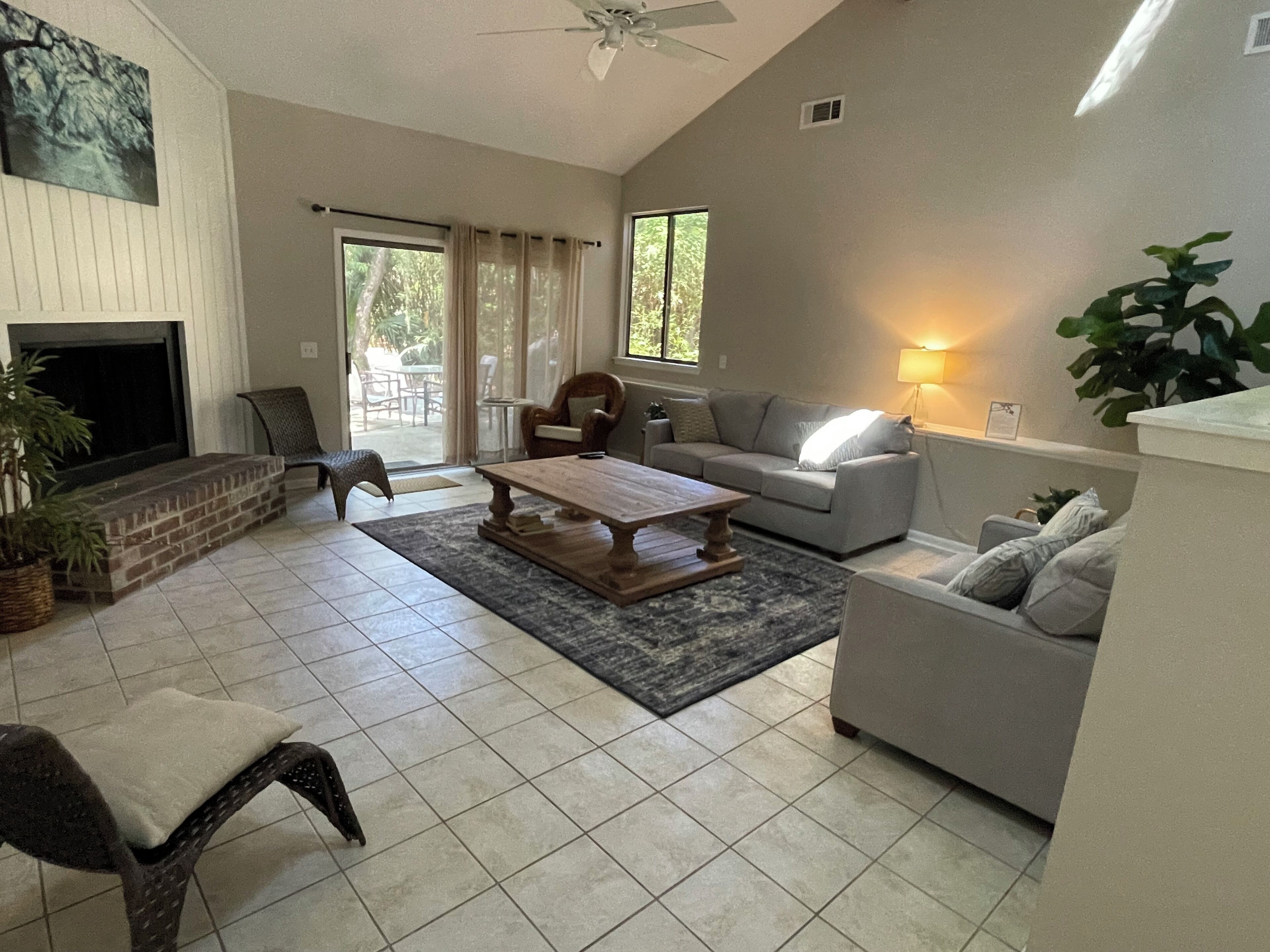 A spacious living room with a fireplace, a sofa, a coffee table, and a television.