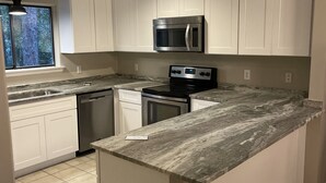 A kitchen with white cabinets, a stainless steel microwave, a stove, and a dishwasher. - WOW! WHAT A DEAL for a HOUSE in SeaPines! Great Locations 2 BR -Pets ok (Hilton Head Island)