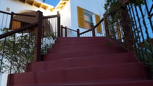 A staircase leading up to a building with a white facade and a yellow window trim. - [A]MOUR HEART OF HOSPITALITY! (Hamilton)