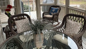 A covered porch with wicker furniture, a glass table, and a view of the neighborhood. - Lovely Home, Perfect location, Coliseum, Golf, HPU, Back Porch & Community pool (Jamestown)