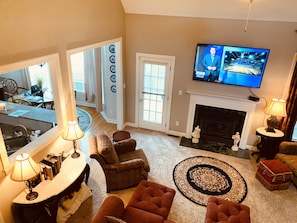 A living room with a fireplace, a television, and a dining area with a table and chairs.