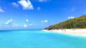 A beach with clear turquoise water and a sandy shore. - Private Gated Ocean Front Villa Pool&Tide Pool Cane Bay Beach Wifi Wedding Venue (Christiansted)