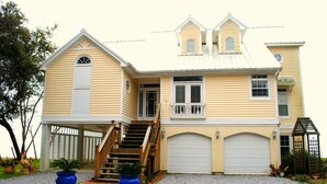 A two-story house with a front porch, a staircase, and a garage. - Gulf Front With Great Views And Pool! (Ocean Springs)