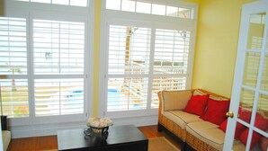 A room with a sofa, a coffee table, and a view through large windows. - Gulf Front With Great Views And Pool! (Ocean Springs)