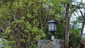 A sign for Jayhawk Villa with a stone base and a lantern on top, surrounded by greenery and mulch. - Beautiful views, walk to Secret Harbour Beach (St. Thomas, VI)
