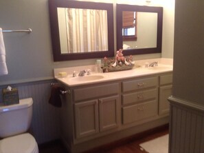 A bathroom with a double sink vanity, a toilet, and a mirror above the sink. - summer dates avail/classic updated Intowncottage/pets ok/great screenporch&deck (Highlands)