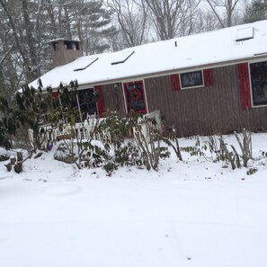 A house with a snow-covered roof and a front yard with bare trees and shrubs. - summer dates avail/classic updated Intowncottage/pets ok/great screenporch&deck (Highlands)