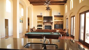 A pool table in a spacious room with a fireplace, leather seating, and a large TV. - Albuquerque Home w/ Heated Pool & Hot Tub Near Balloon Fiesta (Albuquerque)