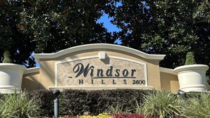Een bordje voor Windsor Hills met een aangelegde tuin ervoor.