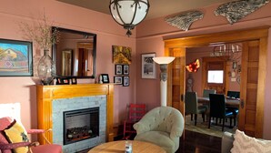 Una sala acogedora con chimenea, una mesa redonda de madera y asientos cómodos.