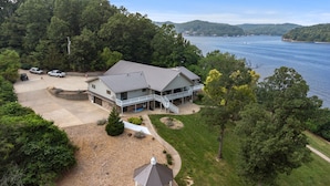 Une grande maison dotée d’un porche abrité et offrant une vue sur un lac.