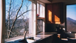 A kitchen with a large window overlooking a mountainous landscape. - Mountainview House - Luxurious Privacy Above the Clouds (Aquone)