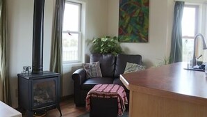 Una sala de estar acogedora con chimenea, un sofá, una mesita de centro y un cuadro en la pared.