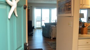 Un pasillo que da a una sala de estar con vistas al exterior.