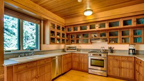 A kitchen with wooden cabinets, a dishwasher, a stove, and a microwave. - Discover an Architectural Gem West (Vail)