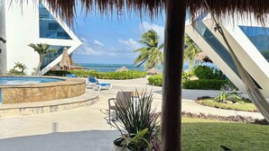 A resort with a pool, lounge chairs, and a view of the ocean. - Oceanfront Luxury Home Wifi 4 Smart TV'S Pool & Spa  (Puerto Morelos)