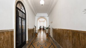 A hallway with a patterned floor, white walls, and wooden paneling. - Balboa - Via Veneto Luxury Apartment Roma 7 bedrooms, 7 bathrooms, 14 sleeps (Roma)