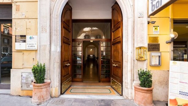 A hotel entrance with a large wooden door, a sign for a bar, and a room service menu. - Balboa - Via Veneto Luxury Apartment Roma 7 bedrooms, 7 bathrooms, 14 sleeps (Roma)
