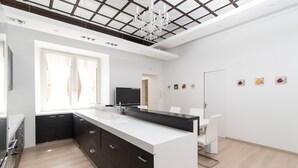 A modern kitchen with a large island, white cabinetry, and a chandelier. - Balboa - Via Veneto Luxury Apartment Roma 7 bedrooms, 7 bathrooms, 14 sleeps (Roma)