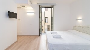 A modern bedroom with a bed, a TV mounted on the wall, and a sliding glass door leading to an outdoor balcony. - Balboa - Via Veneto Luxury Apartment Roma 7 bedrooms, 7 bathrooms, 14 sleeps (Roma)