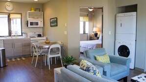 Un espace de vie compact comprenant une kitchenette, un coin repas et un lave-linge.