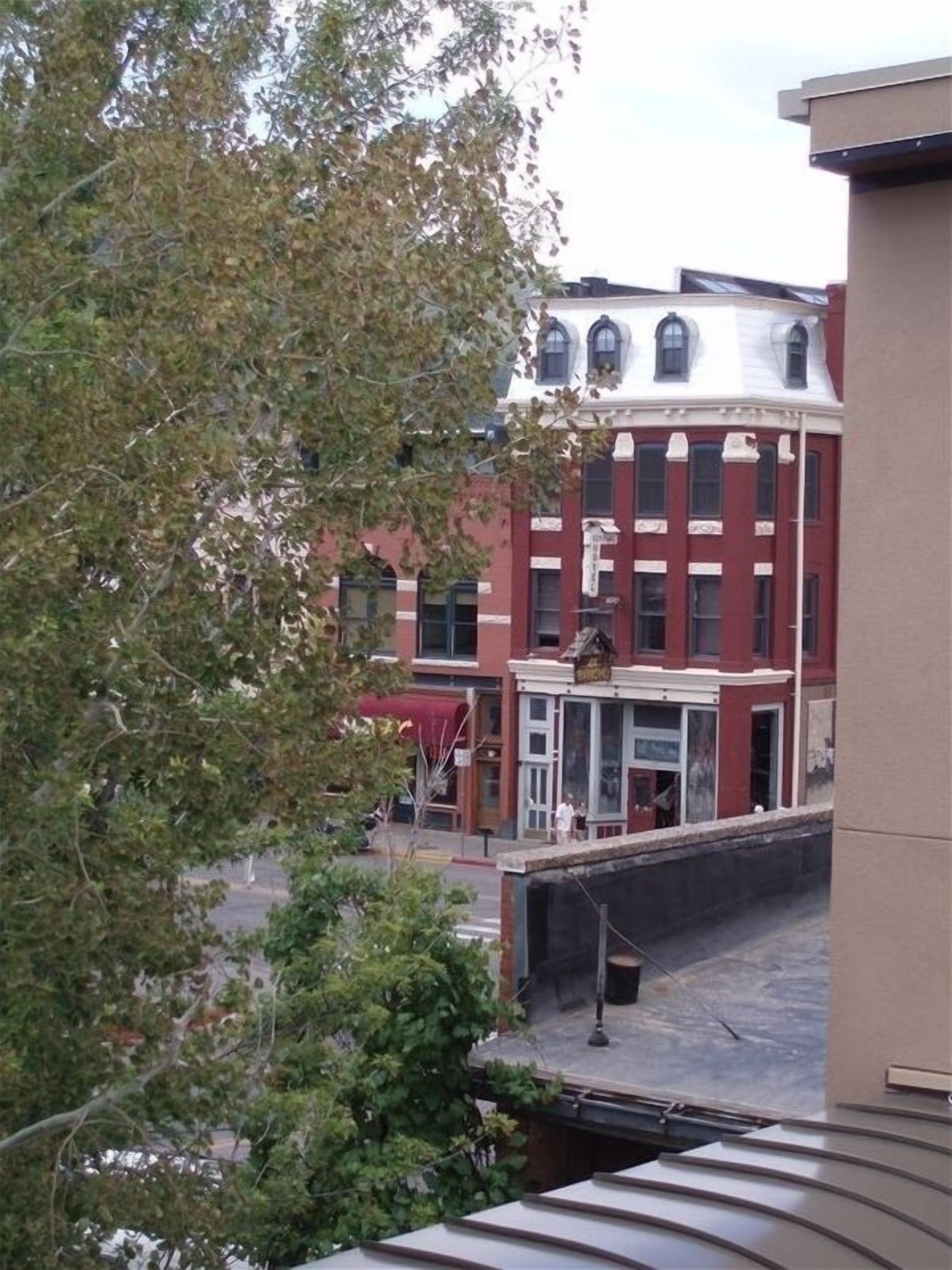 A multi-story building with a red brick facade, large windows, and a flat roof.
