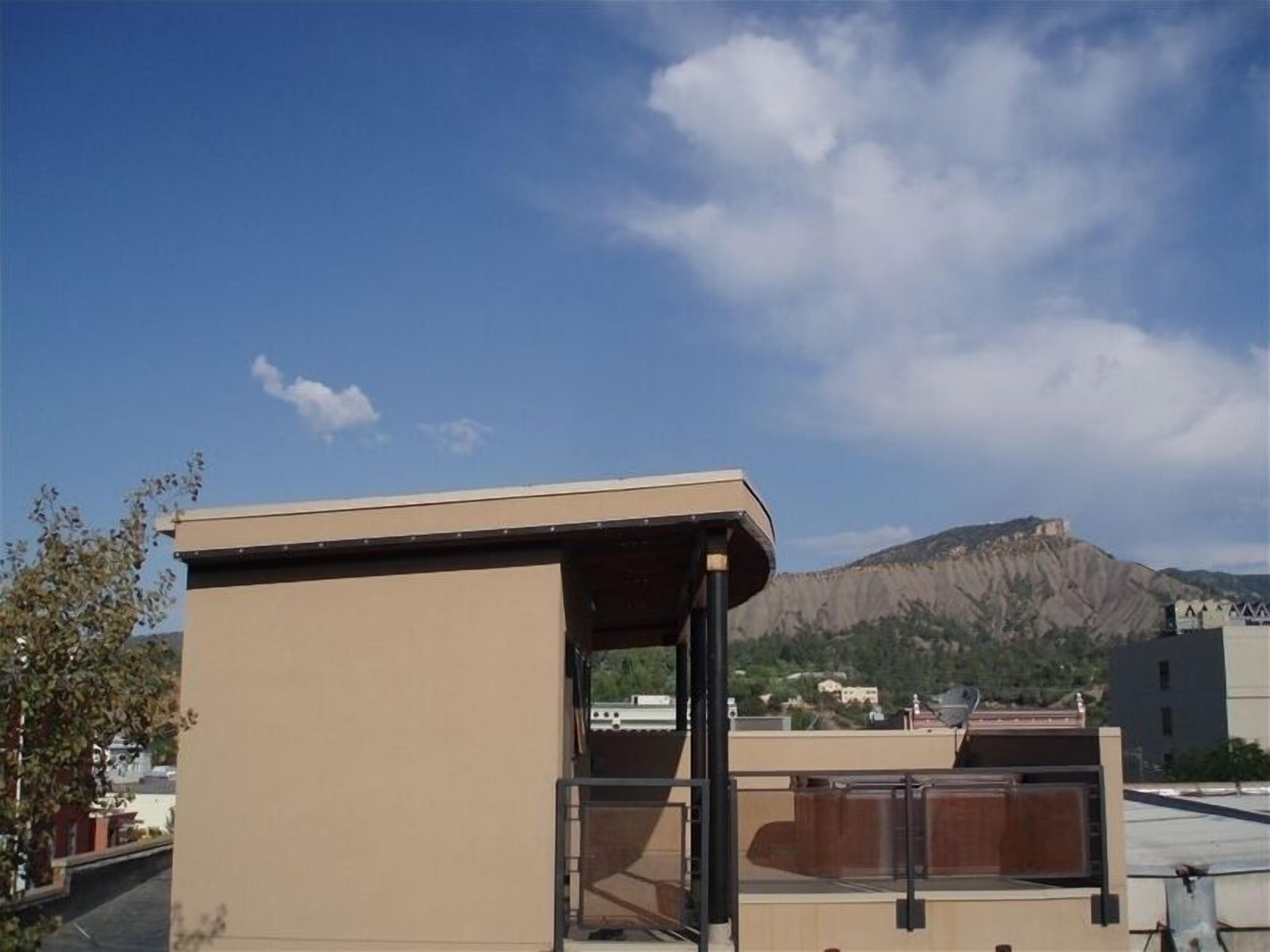 Ein Gebäude mit Flachdach und freiem Blick auf einen Berg im Hintergrund.