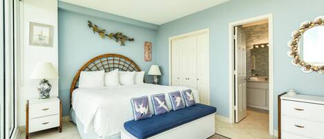 A bedroom with a bed, bedside tables, a bench, a dresser, and a mirror.