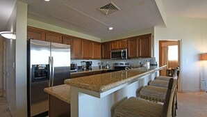 A modern kitchen with granite countertops, stainless steel appliances, and wooden cabinets. - Paraiso Del Mar - La Paz Oceanfront 3 Bedroom (La Paz)
