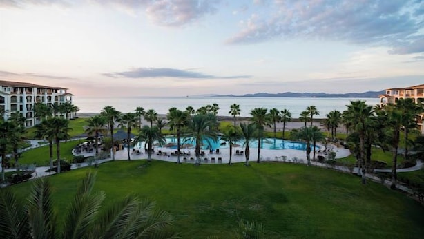 A resort with a swimming pool, palm trees, and a view of the ocean. - Paraiso Del Mar - La Paz Oceanfront 3 Bedroom (La Paz)