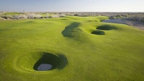 A golf course with multiple bunkers and a clear sky. - Paraiso Del Mar - La Paz Oceanfront 3 Bedroom (La Paz)