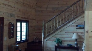 A wooden interior with a staircase, a window, and a small table with a lamp and a plant. - Root River Valley Cabin ~ Lanesboro, MN (Lanesboro)